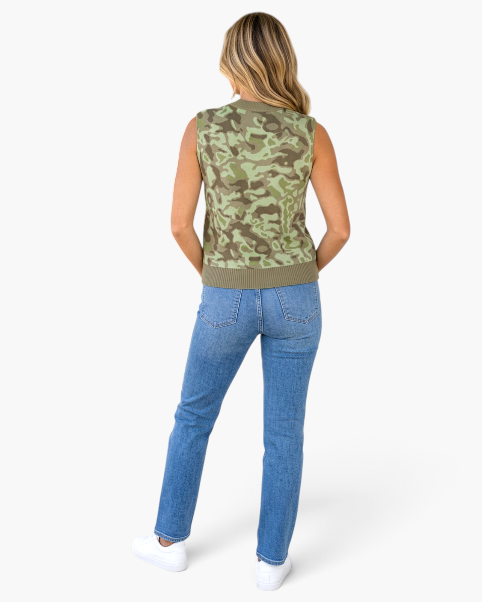 Beach Rose Co. camo print sleeveless sweater vest with ribbed hem worn with blue jeans and white sneakers, back view