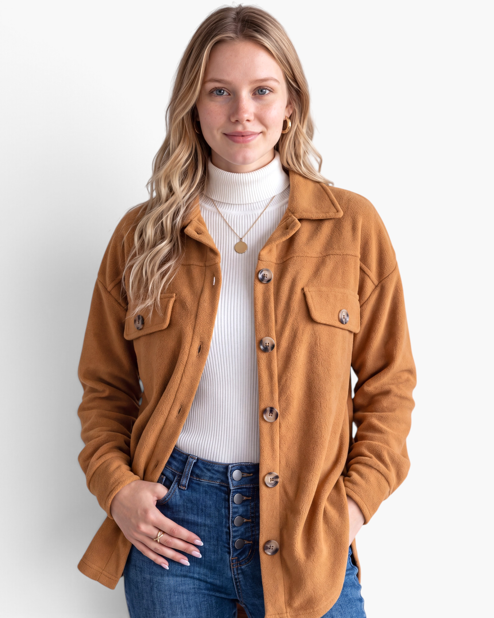 Beach Rose Co. caramel textured button-front shacket worn by a woman over a white turtleneck and blue jeans