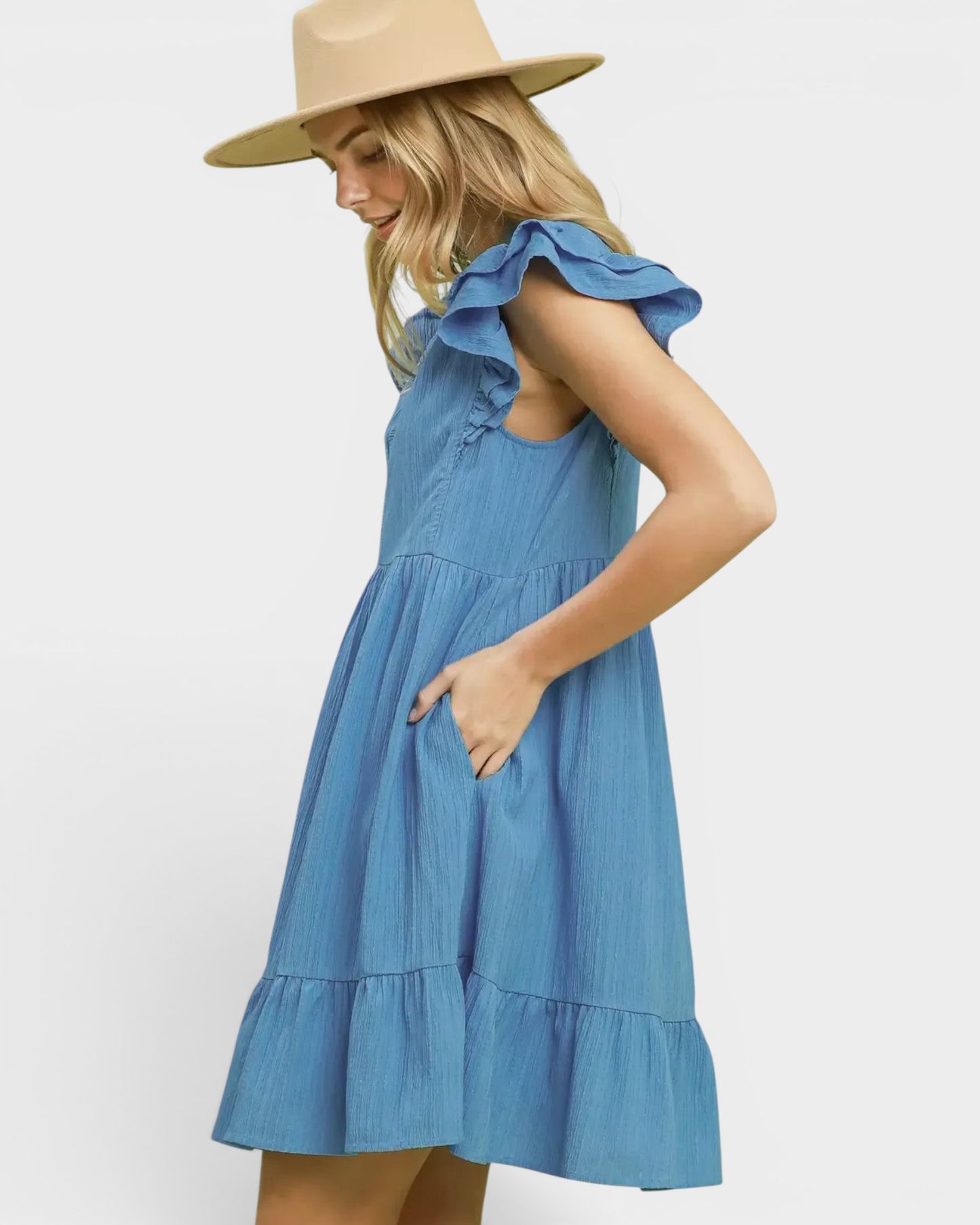 Beach Rose Co. Chambray blue mini dress with ruffle sleeves, split neckline, tiered silhouette, and side pockets. 100% polyester.