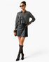 Beach Rose Co. charcoal pinstripe blouse with cascading ruffles, worn by a model with a black leather skirt.