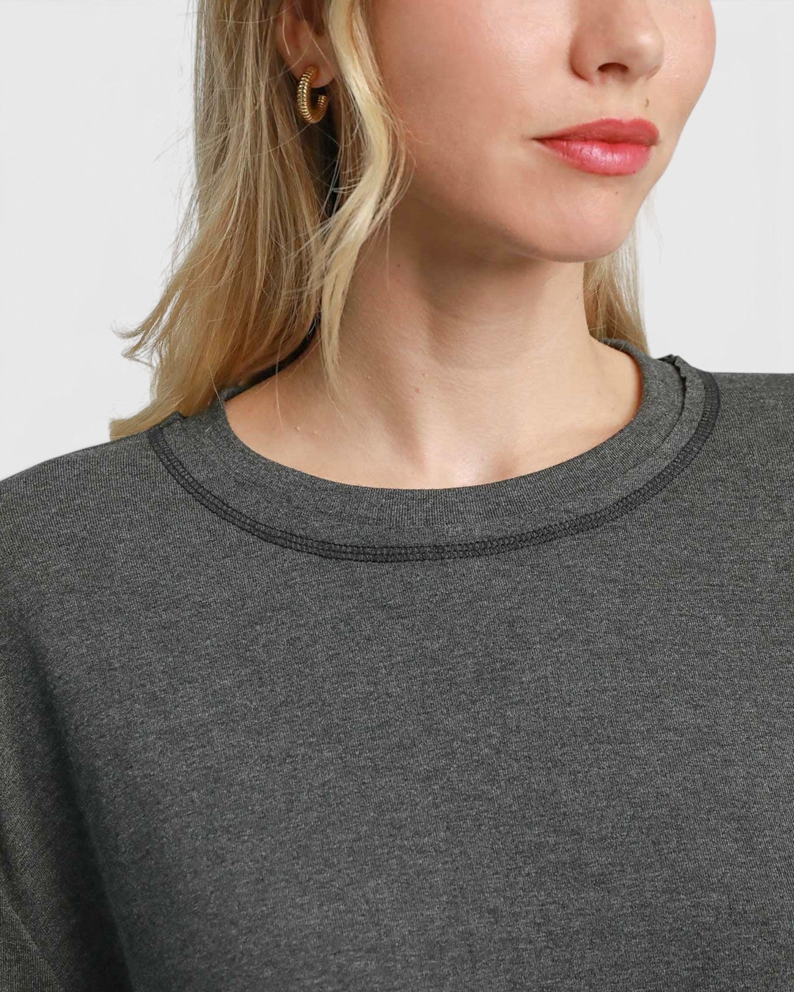 Beach Rose Co. charcoal grey stretch modal basic top with a crew neckline worn by a woman with gold hoop earrings.