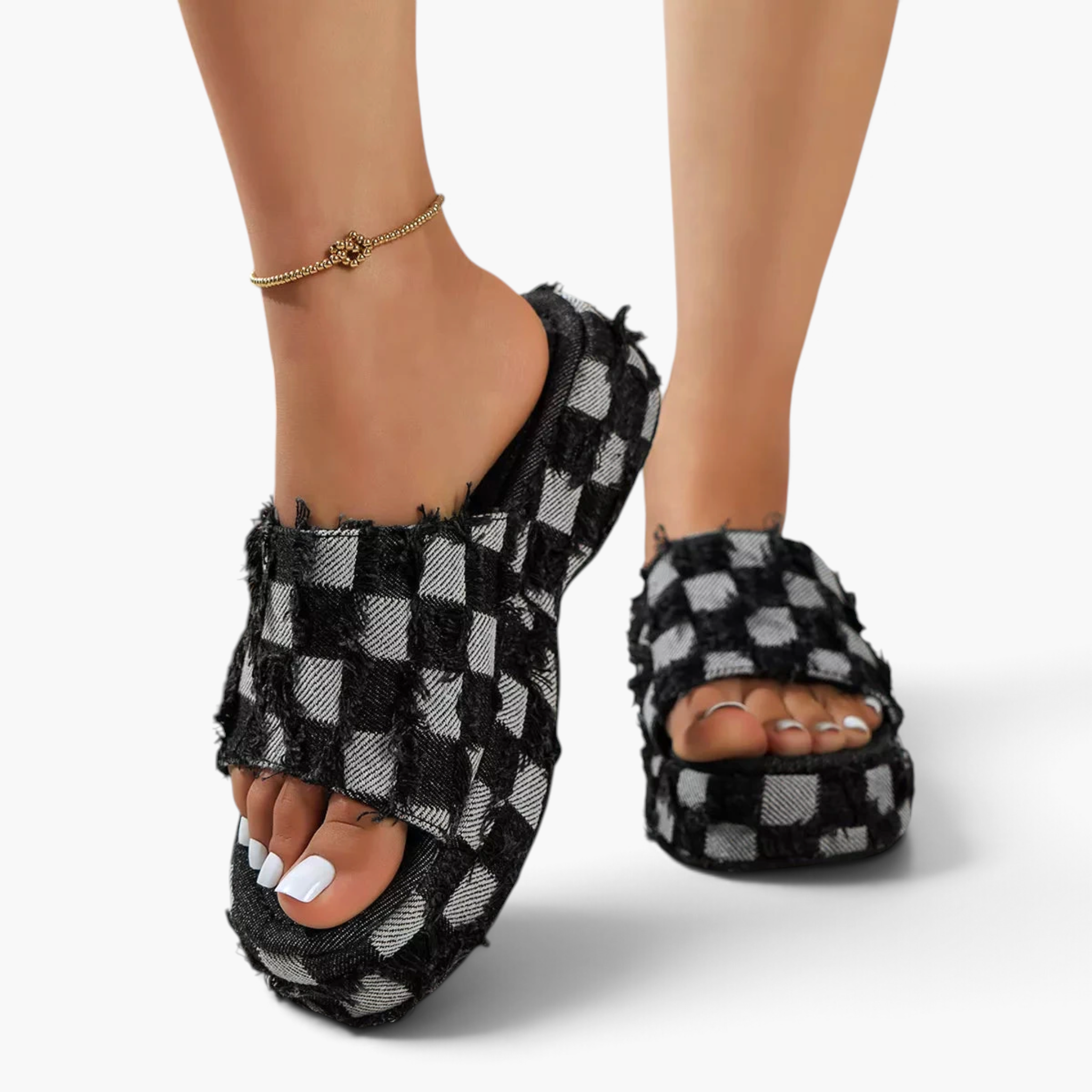 Beach Rose Co. black and white checkered denim platform slides with frayed edges on a model's feet.