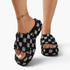 Beach Rose Co. black and white checkered denim platform slides with frayed edges on a model's feet.