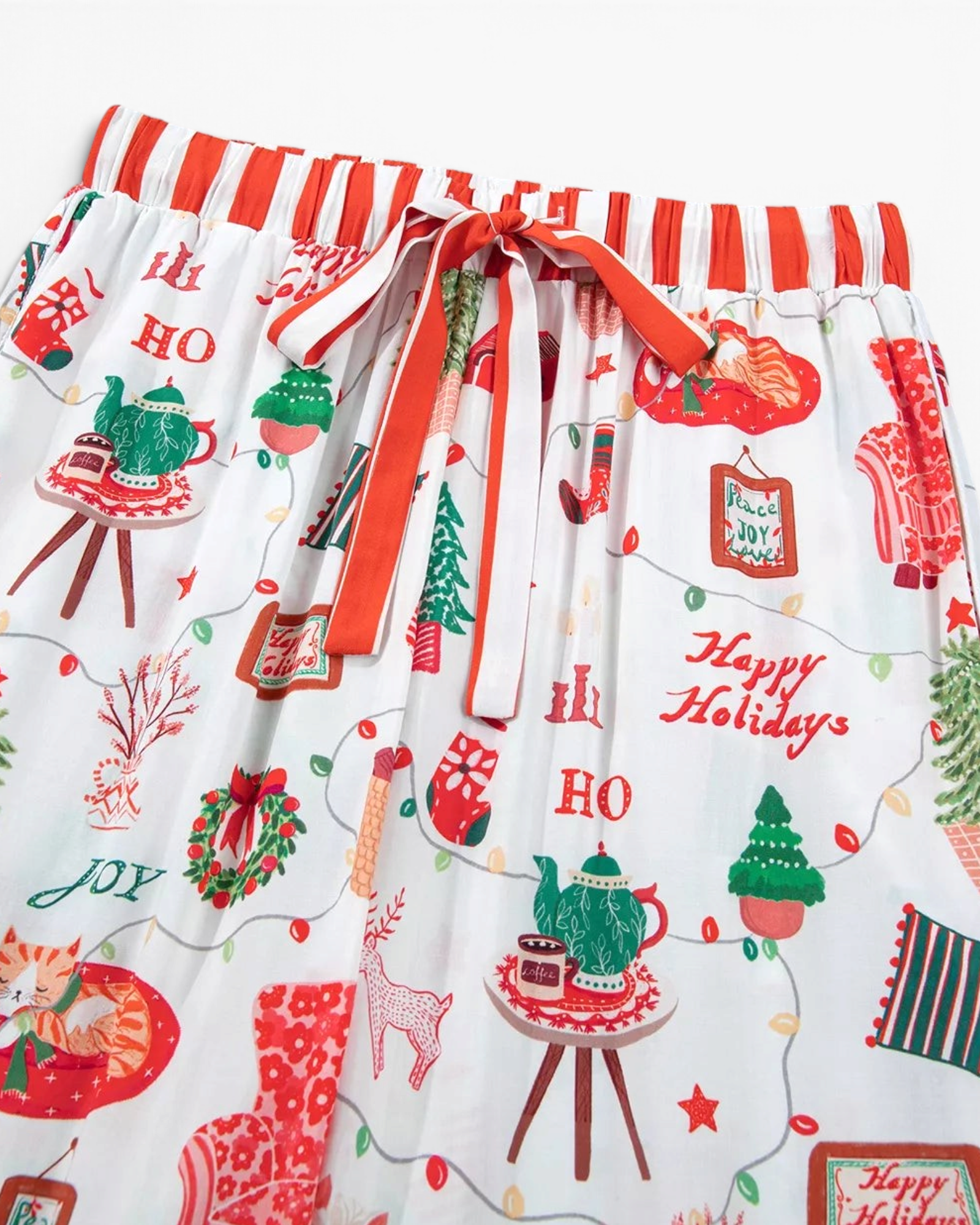 Beach Rose Co. white pajama pants with festive Christmas print, red and white striped waistband, and drawstring tie.