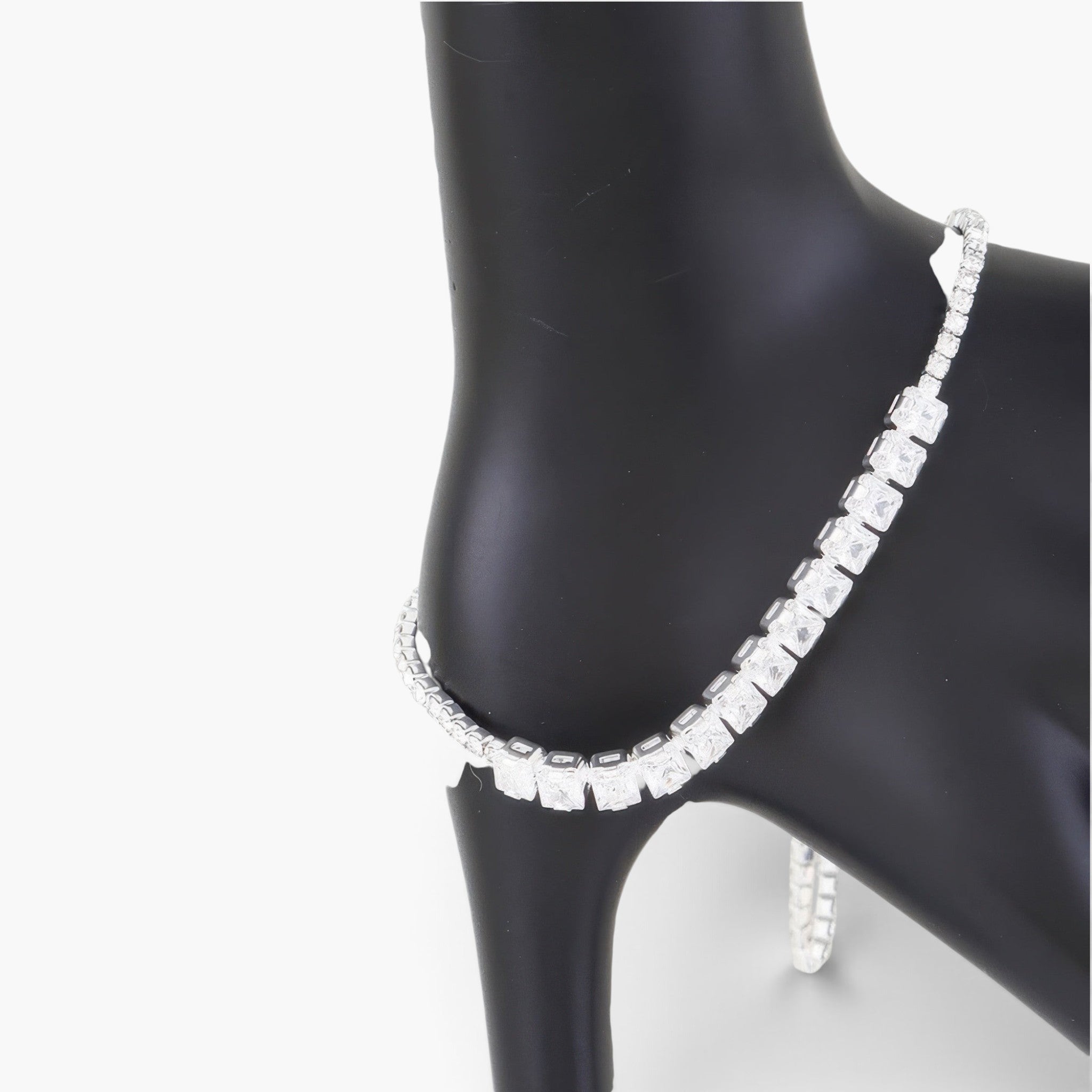 Beach Rose Co. tennis bracelet featuring a row of clear square-cut cubic gemstones on a black display stand