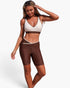 Beach Rose Co. two-piece color block yoga set with a sleeveless sports bra and brown biker shorts in stretch fabric.