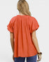 Beach Rose Co. coral orange puff sleeve blouse with gathered V-neckline and textured fabric.