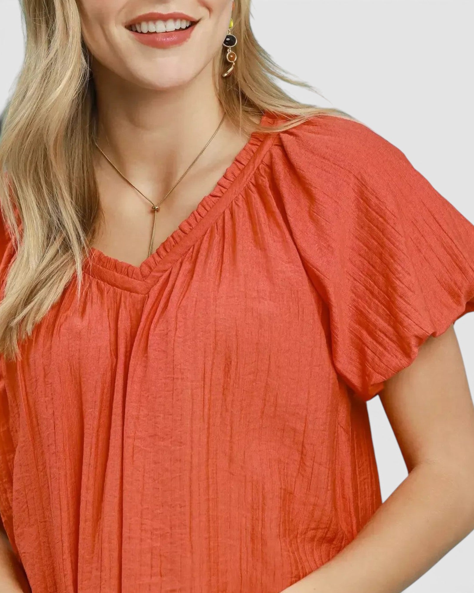 Beach Rose Co. coral orange puff sleeve blouse with gathered V-neck and textured fabric.