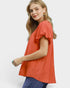 Beach Rose Co. coral orange puff sleeve blouse with gathered V-neckline and textured fabric.