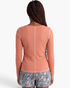 Back view of Beach Rose Co. coral ribbed long sleeve top with contrast seam detailing on a model.