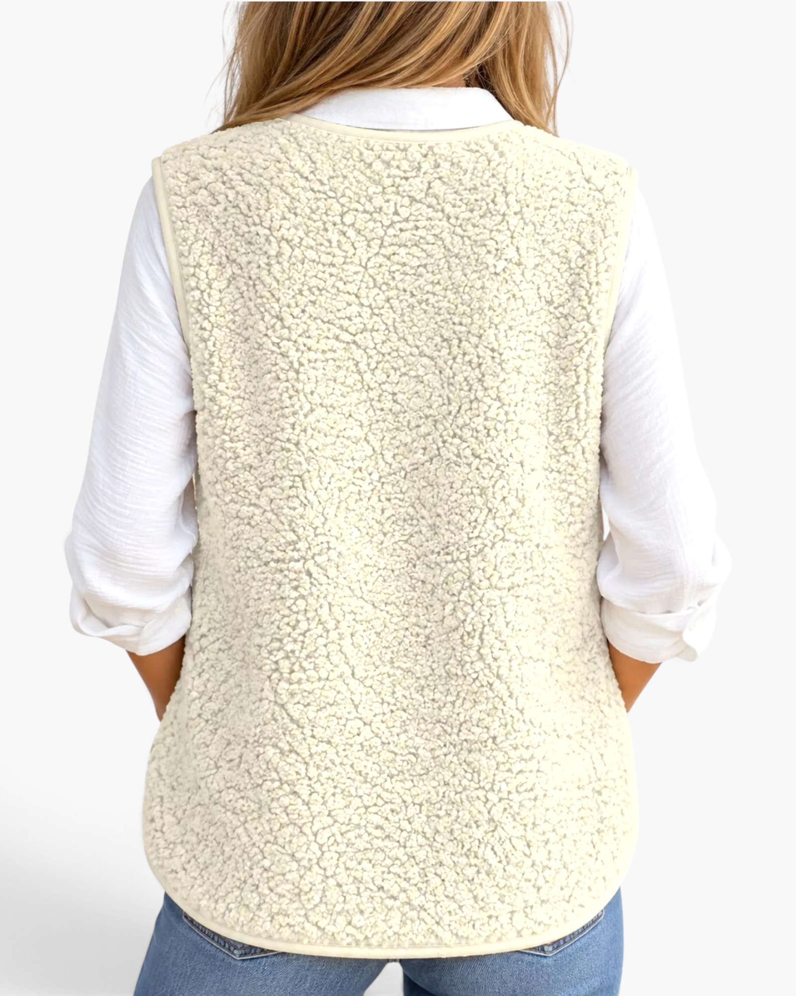 Back view of a woman wearing a Beach Rose Co. cream polar fleece vest over a white shirt and blue jeans.