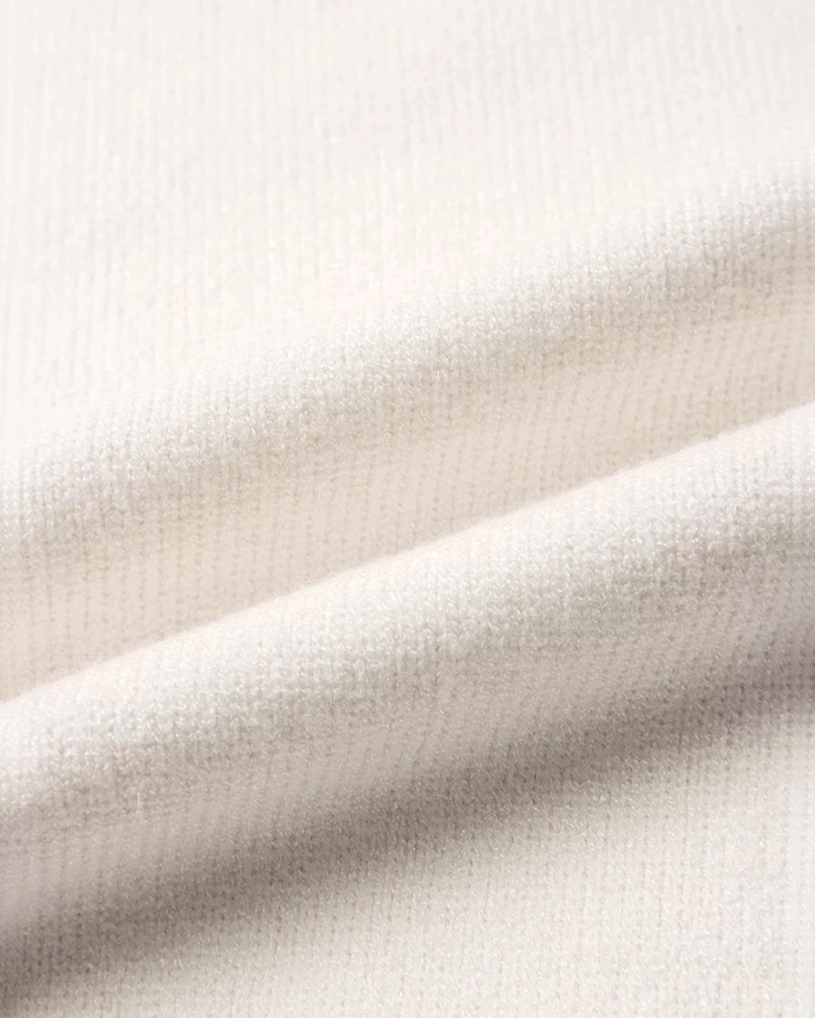 Close-up of soft cream knit fabric texture from a Beach Rose Co. Christmas sweater.