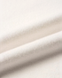 Close-up of soft cream knit fabric texture from a Beach Rose Co. Christmas sweater.