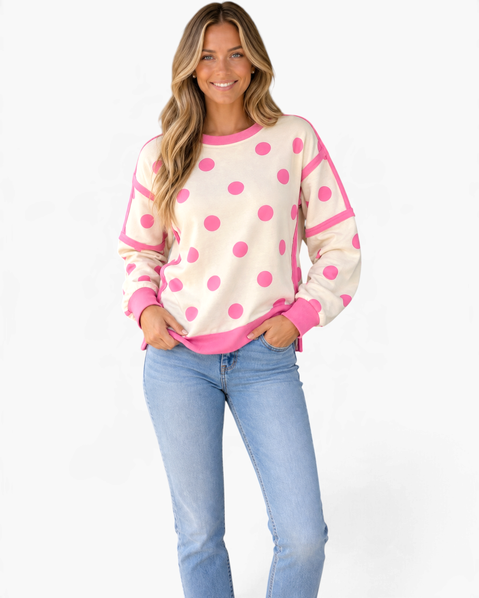 Beach Rose Co. cream sweatshirt with pink polka dots, exposed seams, and ribbed trim worn by a smiling model.