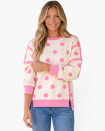 Beach Rose Co. cream sweatshirt with pink polka dots, exposed seams, and ribbed trim worn by a smiling woman.