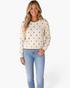 Beach Rose Co. cream cotton sweater with brown polka dots, crew neck, and scalloped trim worn by a smiling woman.