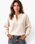 Beach Rose Co. model wearing a cream ribbed quarter-zip pullover with dropped shoulders and banded cuffs.