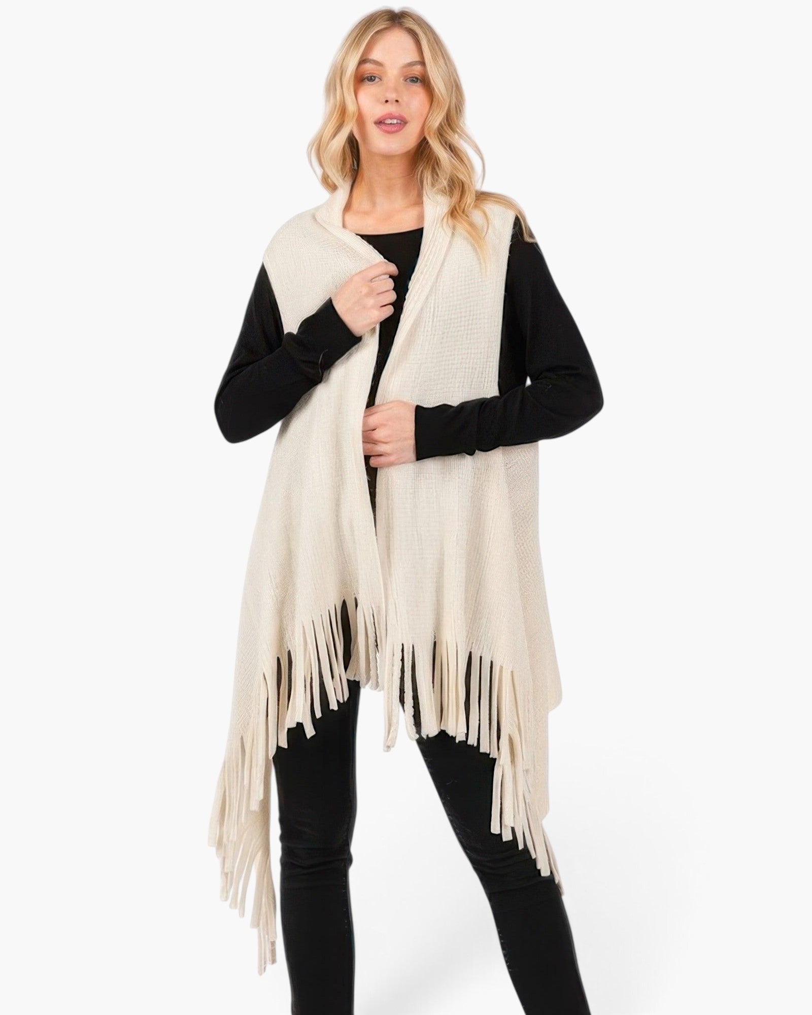 Beach Rose Co. cream knit vest with embossed dotted texture and tassel fringe hem worn over a black long sleeve top