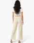 Beach Rose Co. relaxed fit wide-leg cotton pants in cream worn by a woman with long dark hair, back view.