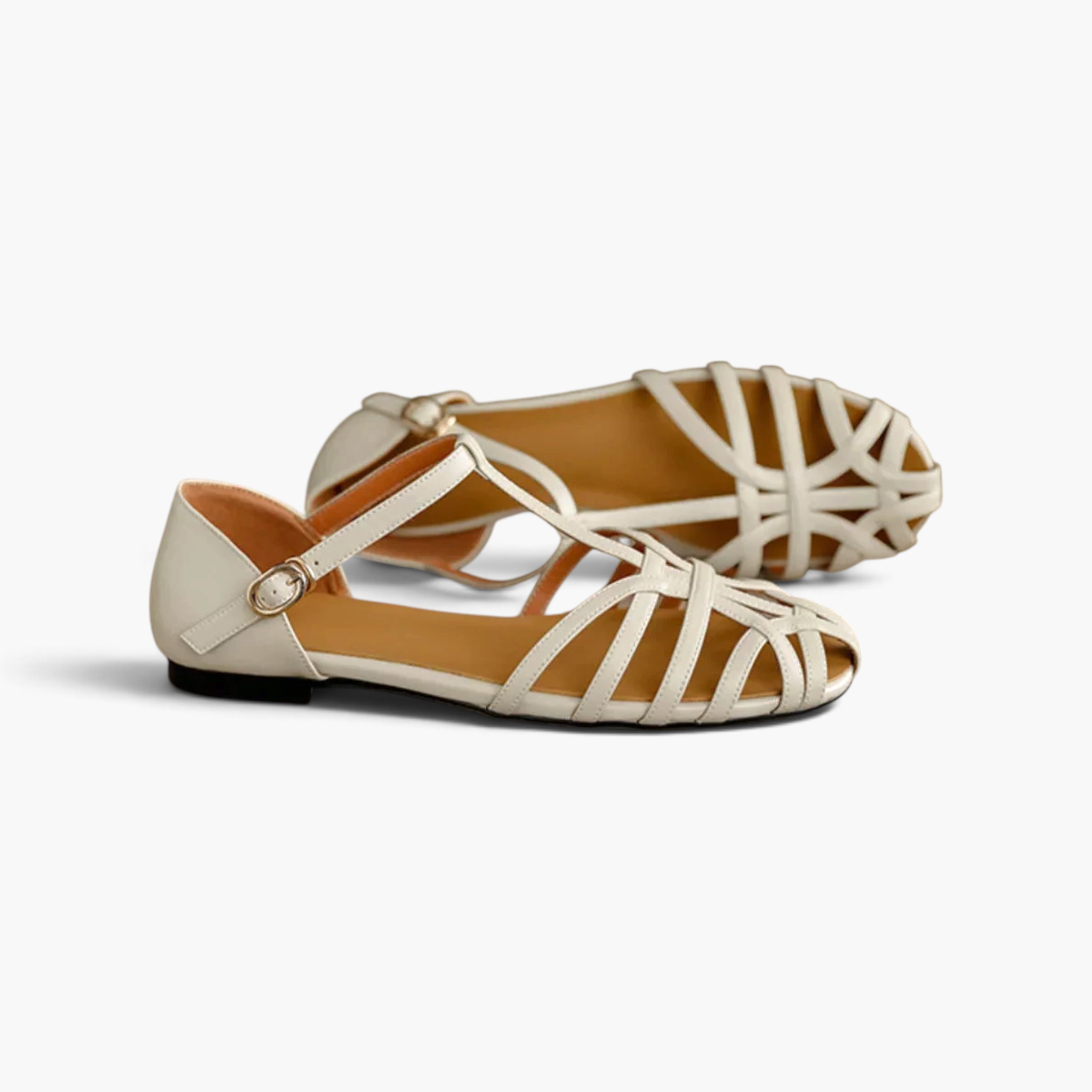 Beach Rose Co. cream PU leather T-bar flat sandals with an interwoven caged strap design and adjustable buckle.