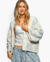 Beach Rose Co. ivory and light blue patchwork crochet open-front cardigan with three-quarter sleeves on a model