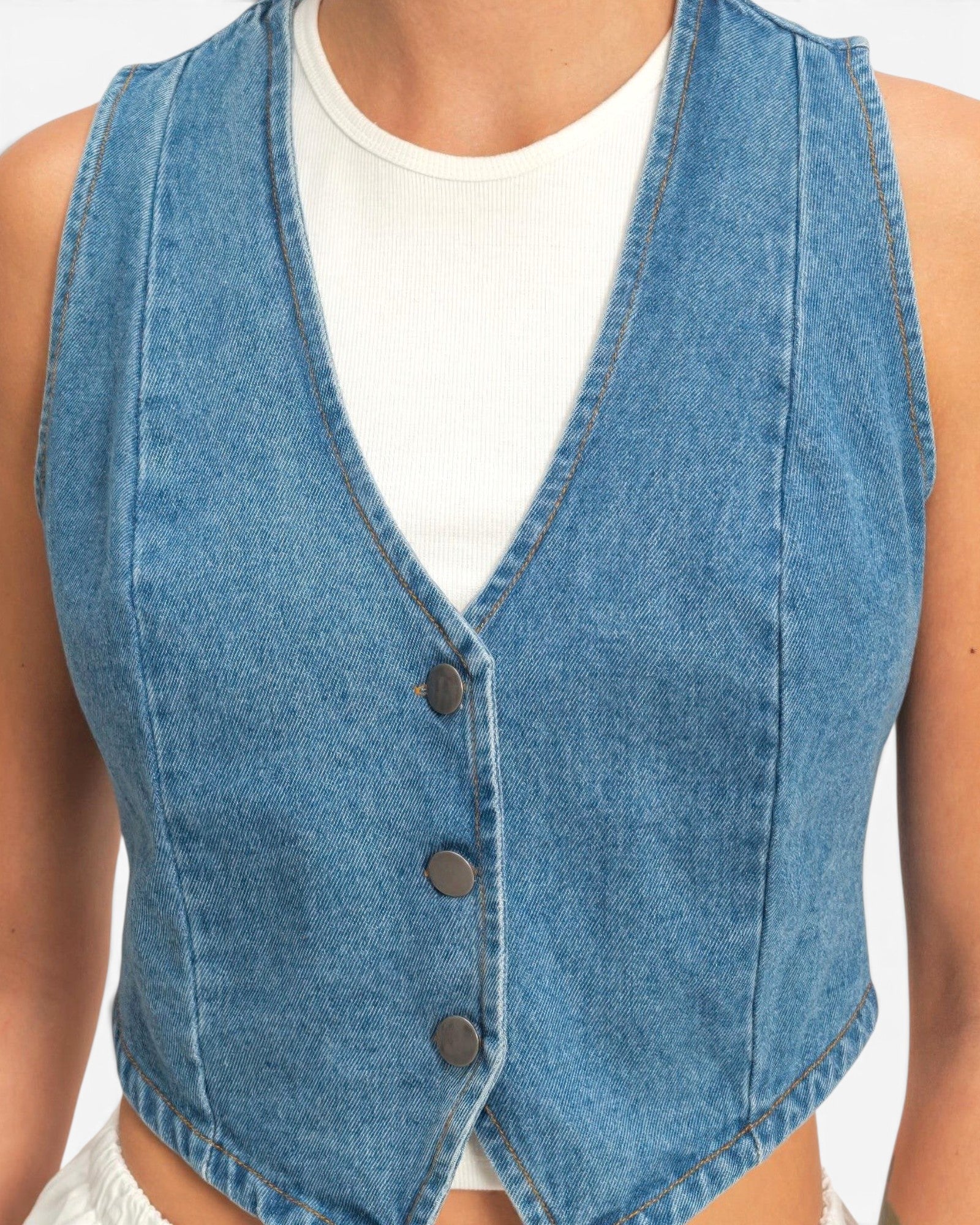 Beach Rose Co. cropped blue cotton denim vest with a V-neck, button-front closure, and structured sleeveless fit.