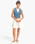 Beach Rose Co. cropped blue denim vest with V-neck and button front, worn over a white top and skirt.