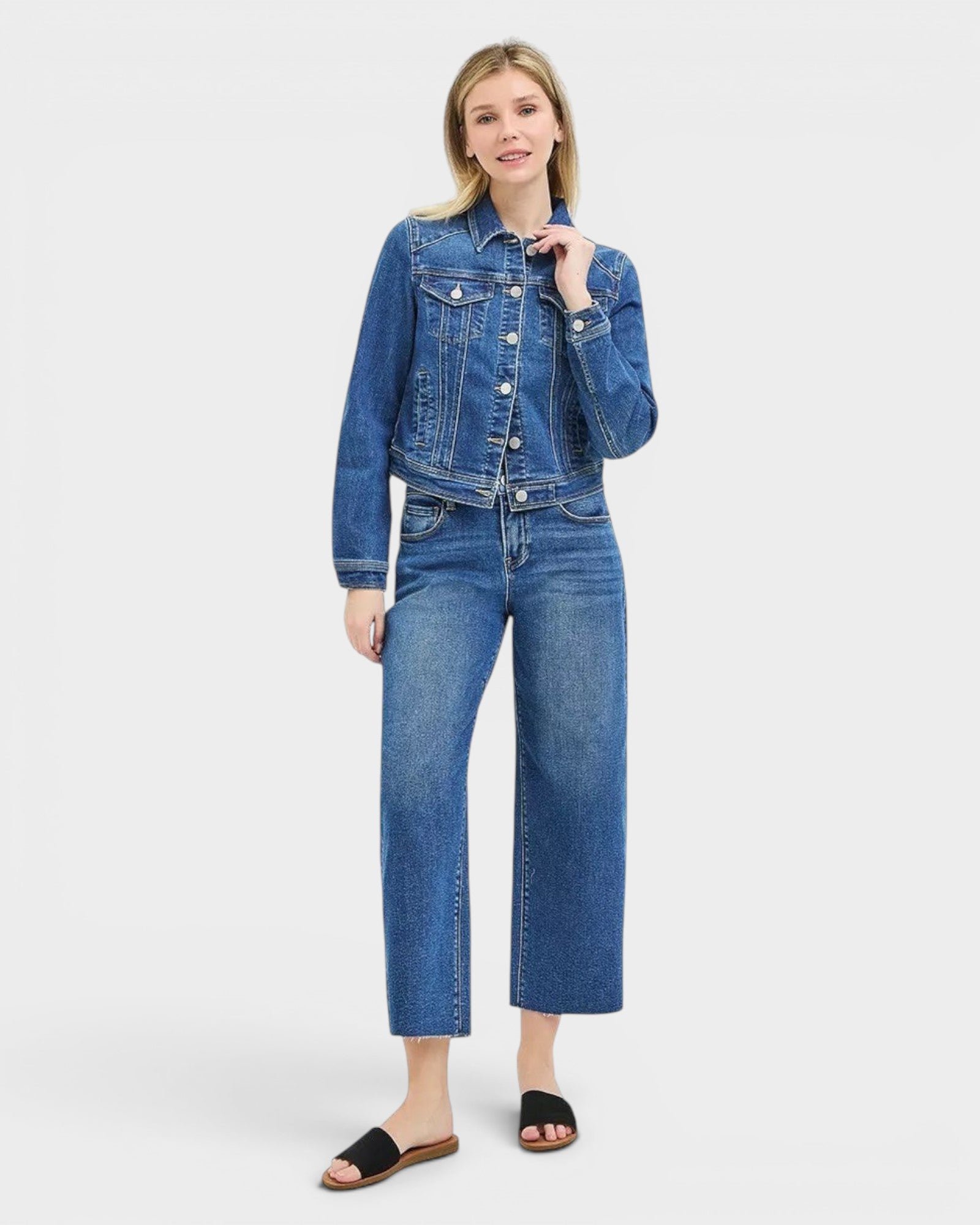 Beach Rose Co. dark wash cropped denim jacket with collared neckline, button front, and chest flap pockets. Made of cotton blend.