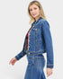 Beach Rose Co. dark wash cropped denim jacket with collared neckline, button front, and chest flap pockets. Made of cotton blend.
