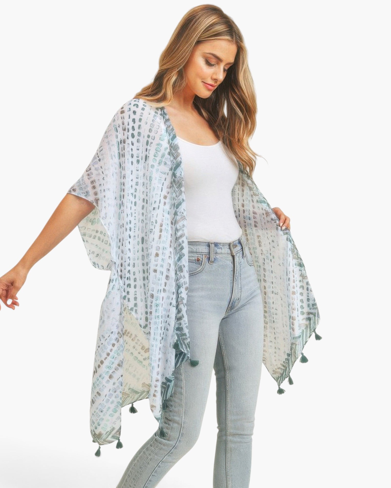 Beach Rose Co. model wearing a lightweight white kimono with a multi-dash pattern and green tassel trim.