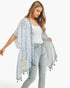 Beach Rose Co. model wearing a lightweight white kimono with a multi-dash pattern and green tassel trim.