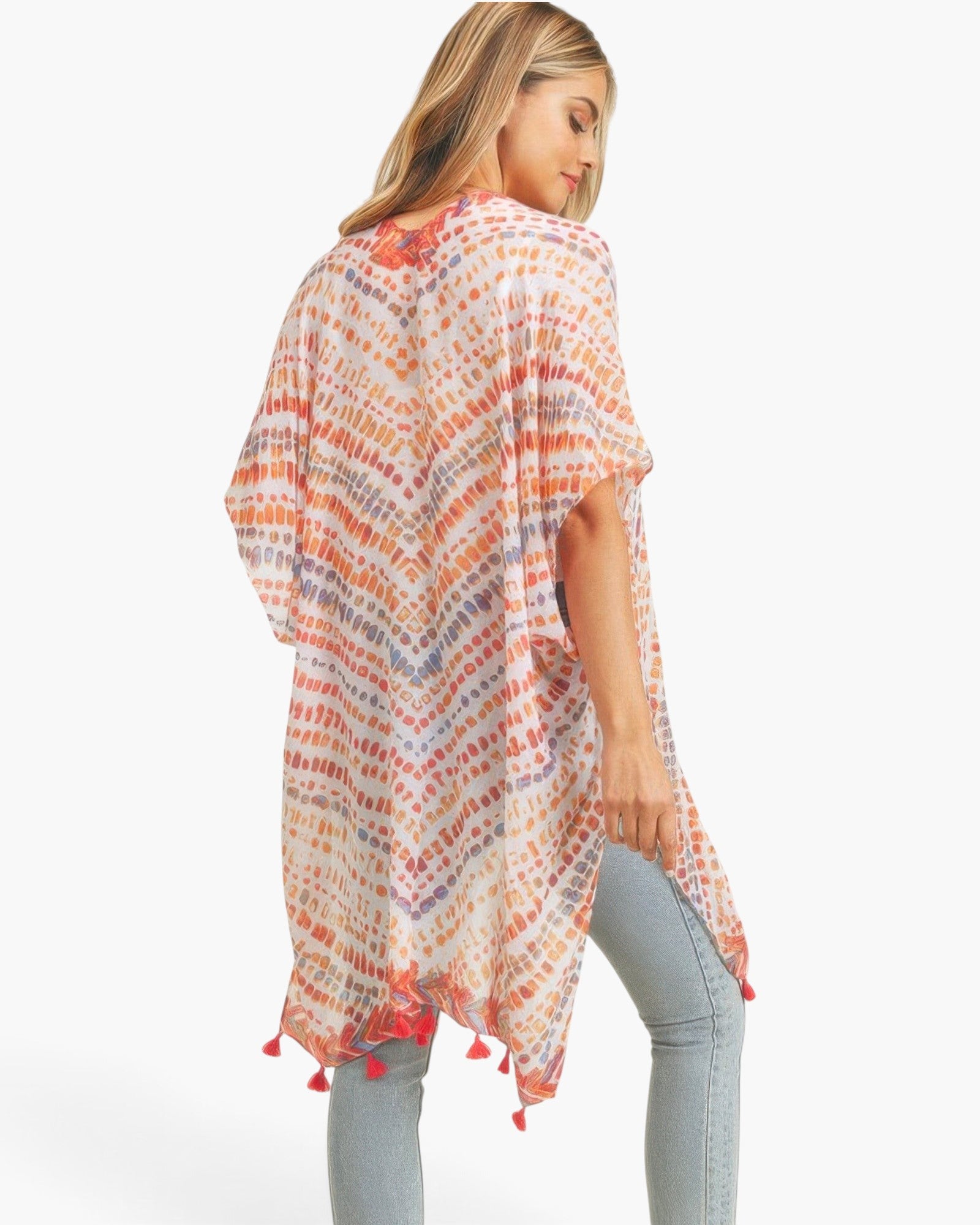 Beach Rose Co. multi dash pattern kimono with tassel trim, worn over light wash jeans, showing a flowy back view.