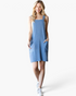 Beach Rose Co. denim blue ribbed overall dress with wide straps and patch pockets worn by a blonde model
