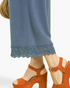 Beach Rose Co. dusty blue linen blend cropped pants featuring a scalloped lace hem, worn with brown platform sandals.