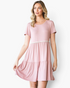 Beach Rose Co. dusty rose babydoll dress with ivory pom-pom trim, tiered skirt, and gathered shoulders on a model.