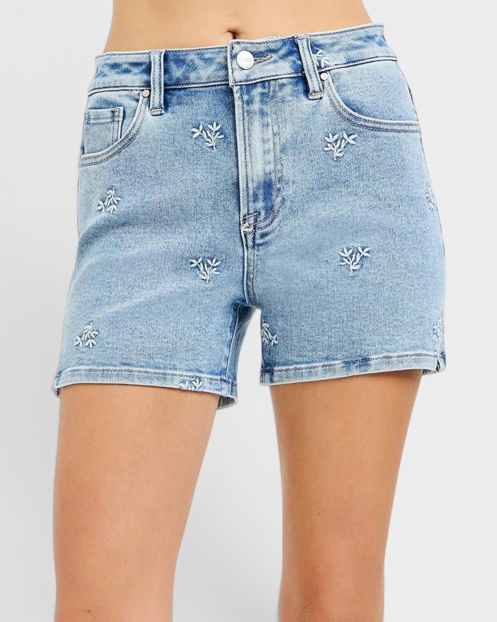 Beach Rose Co. light wash denim shorts with white embroidered floral details, high-rise, and short length.