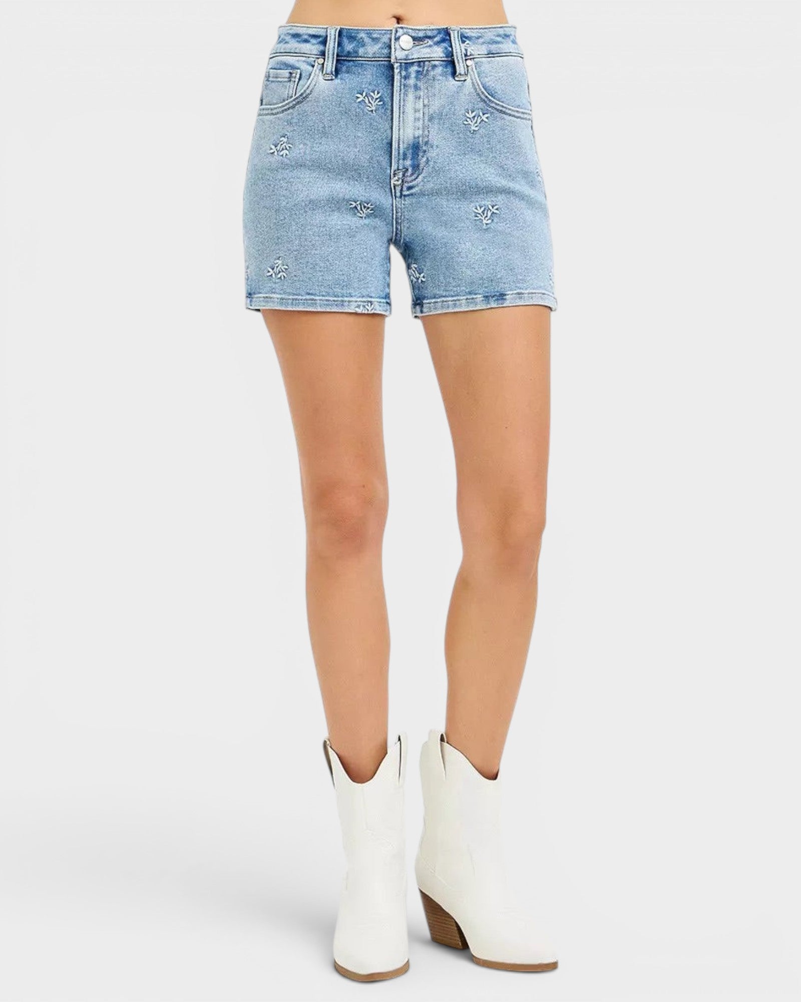 Beach Rose Co. light wash denim shorts with white embroidered floral details, high-rise fit, and short length.