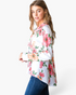 Beach Rose Co. white blazer with pink and coral floral print, notched lapels, and high-low hem worn by a model