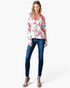 Beach Rose Co. white blazer with pink and coral floral print, notched lapels, and high-low hem worn with blue jeans.