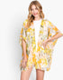 Beach Rose Co. floral print cover-up in yellow and white, worn by a blonde model over a white top.