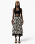 Beach Rose Co. midi skirt with white floral embroidery on black fabric and a sheer tulle hem worn by a model.