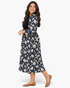 Beach Rose Co. plus size midi dress with black ribbed bodice and navy floral skirt, worn by a smiling woman.