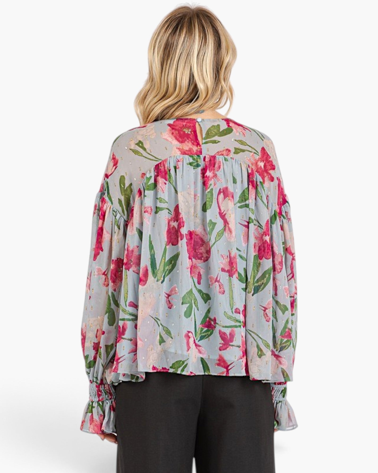 Beach Rose Co. light blue floral blouse with pink flowers, balloon sleeves, and smocked ruffle cuffs, back view.