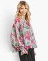 Beach Rose Co. light blue floral blouse with pink flowers, balloon sleeves, and smocked ruffle cuffs on a model.