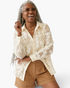 Beach Rose Co. cream button-up blouse with dimensional floral appliqués, sequins, and sheer long sleeves on a model.