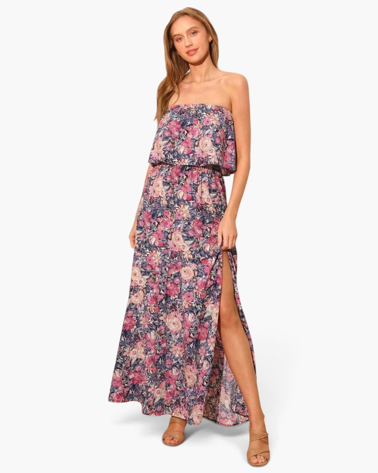 Beach Rose Co. strapless maxi dress in a vibrant floral print with a side slit, worn by a model in tan heels.