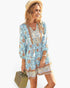 Beach Rose Co. floral viscose V-neck dress with long sleeves and button-down front, worn by a woman with a straw hat.