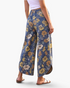 Beach Rose Co. blue floral print wide leg pants with curved hems and back patch pockets on a model