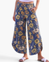Beach Rose Co. blue wide leg pants featuring a yellow and orange floral print, elastic waist, and curved side slits.