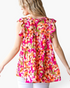 Beach Rose Co. fuchsia floral print tiered top with flutter sleeves and a relaxed fit worn by a blonde woman